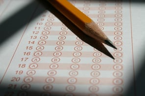 A pencil laying on a Scantron testing sheet.