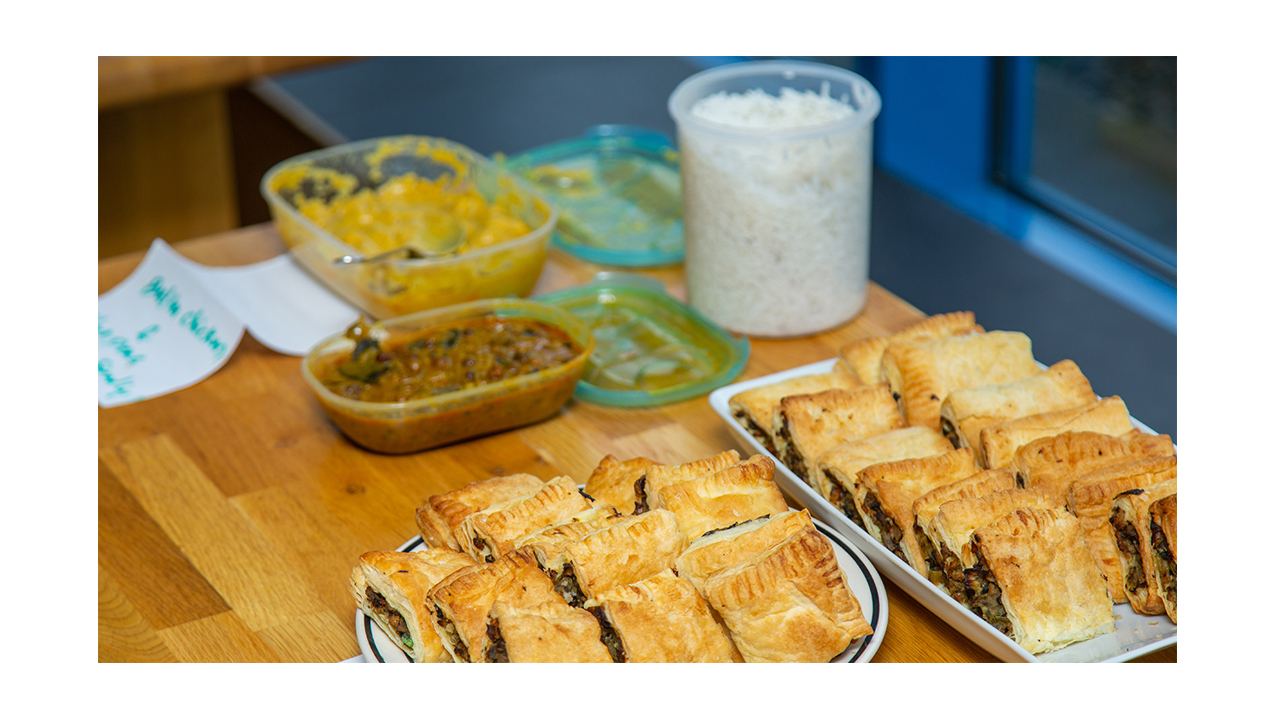 A restaurant table filled with platters of empanadas, salsa and side dishes.