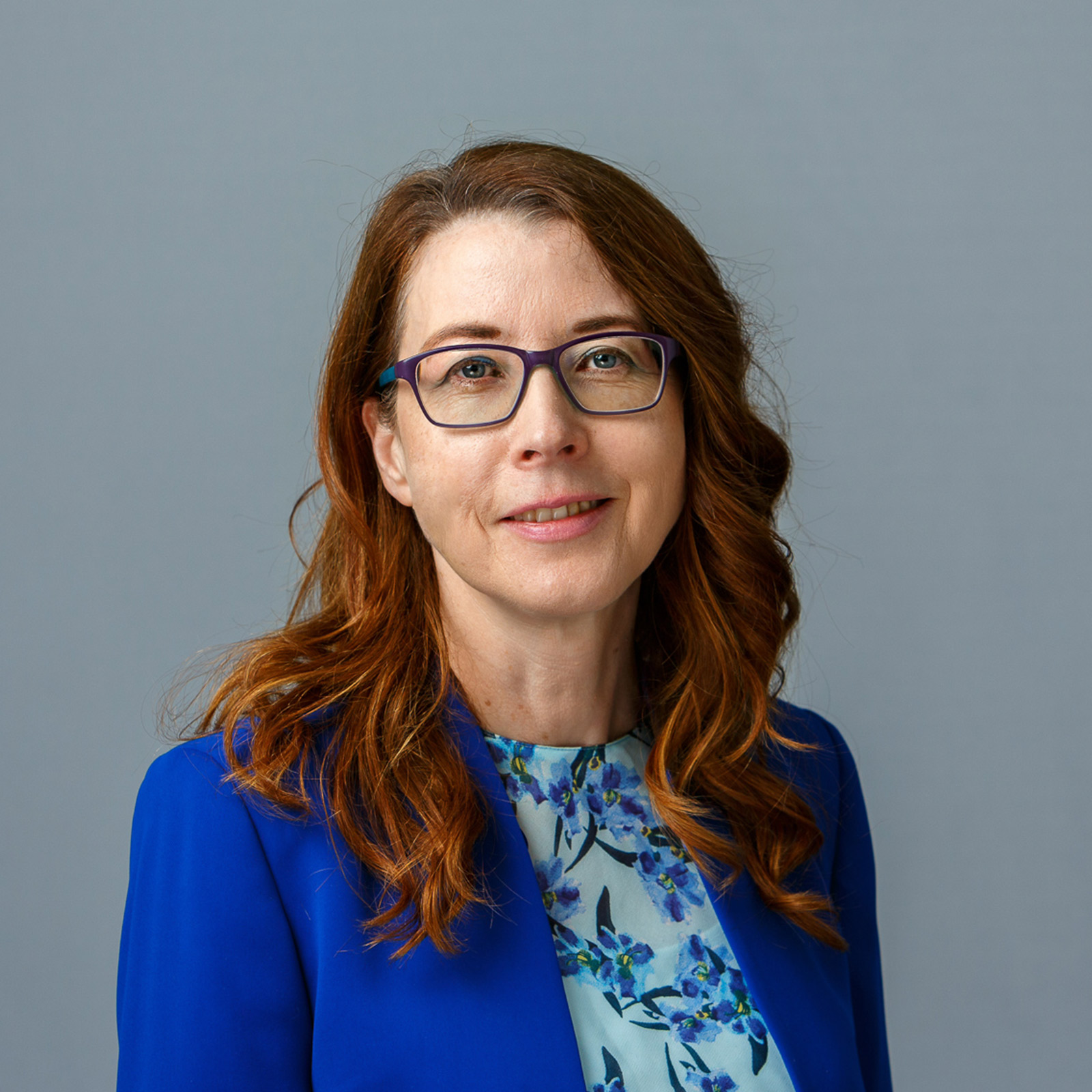 Frances Frolan, who is a sales operation lead at SilverCloud Health, and is wearing a blue blazer and a blue floral blouse.